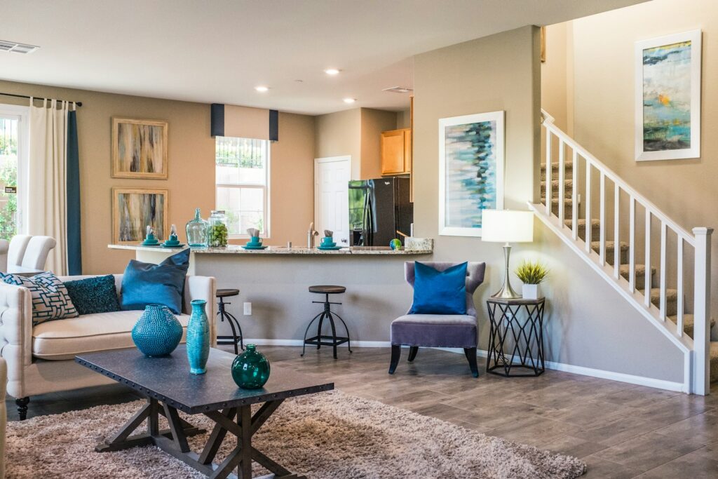 Staged open-concept living room and kitchen with neutral walls and coordinated blue accents