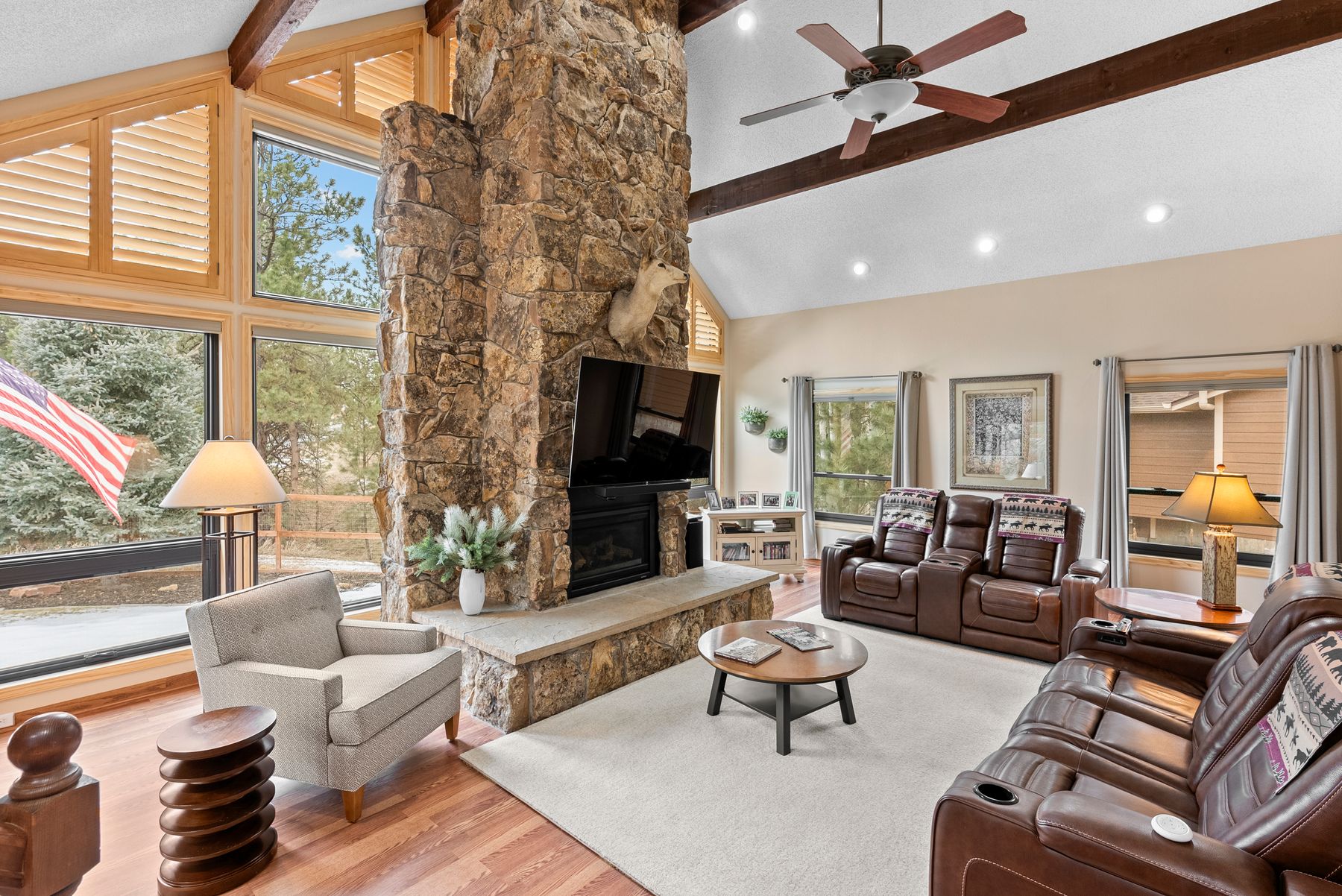 home for sale in the pinery Great room with a stone fireplace and floor-to-ceiling windows at 9724 Villasur Ct.