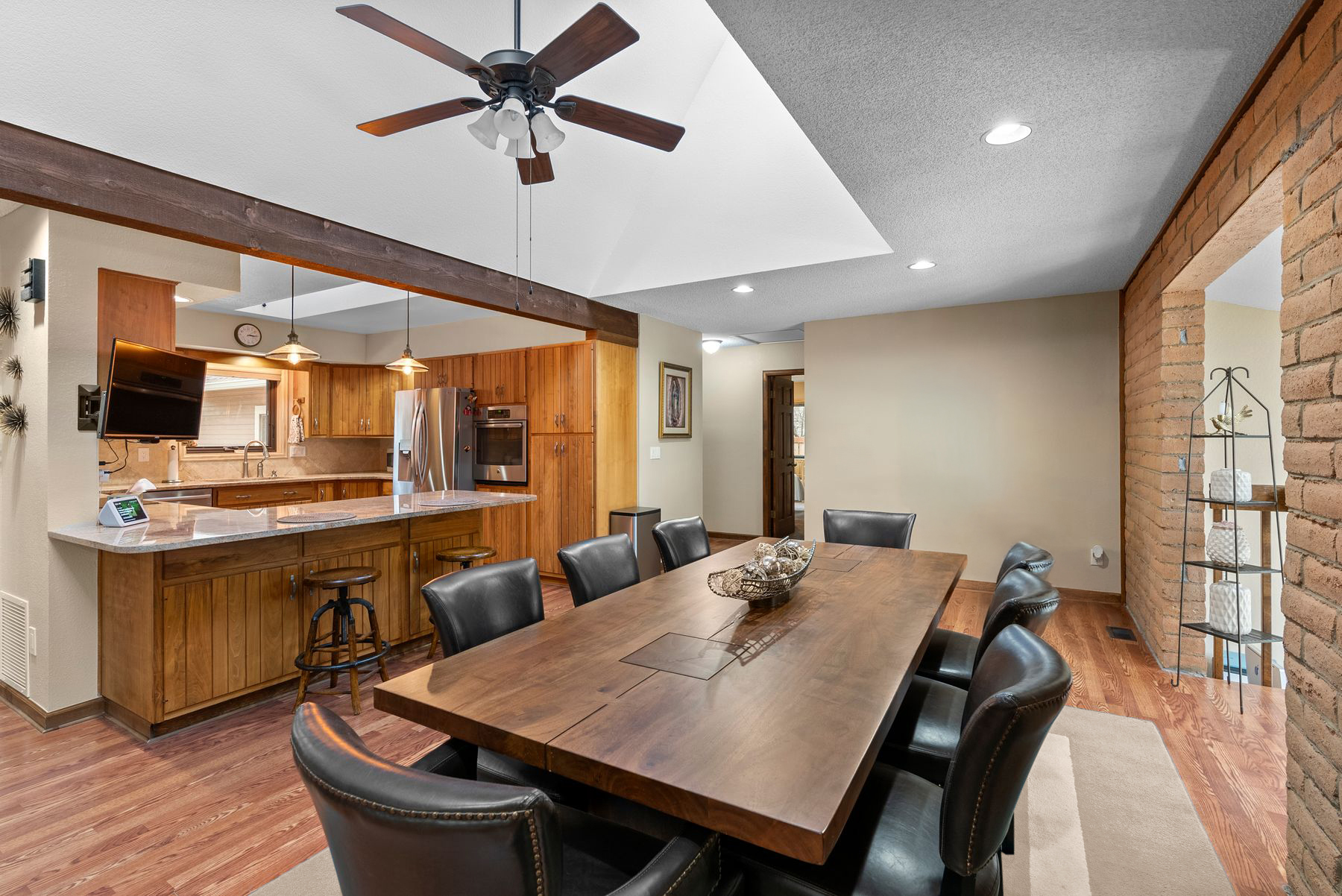 Kitchen and dining area with custom cabinetry and exposed wood beams