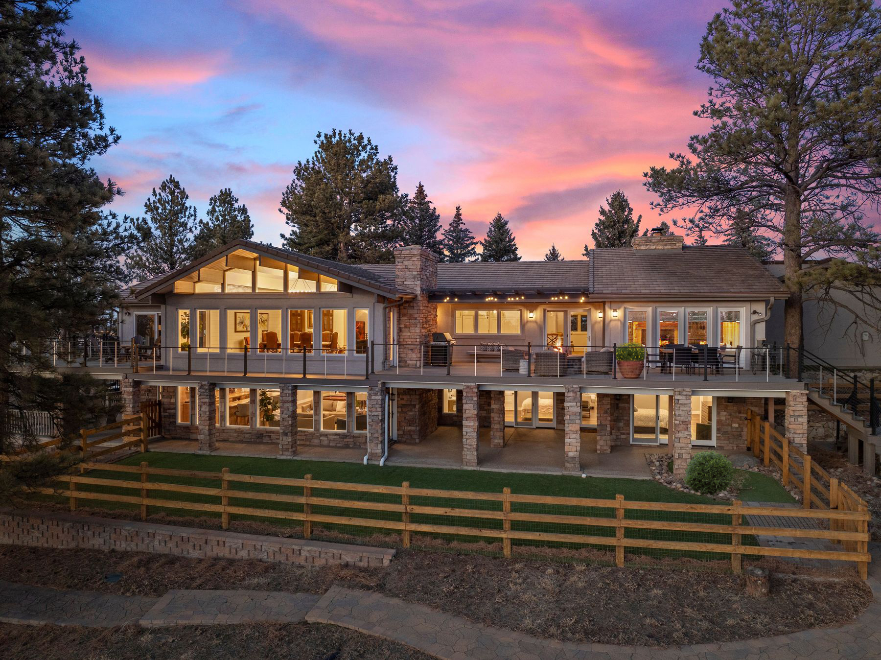 Luxury equestrian estate at 8740 Hilltop Road in Parker, CO at sunset, showcasing the main residence and expansive deck