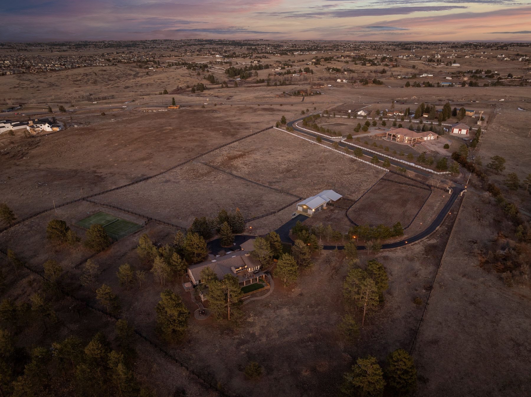 Aerial view of 8740 Hilltop Road showcasing the full 12-acre estate with barn, outdoor arena, and main residence