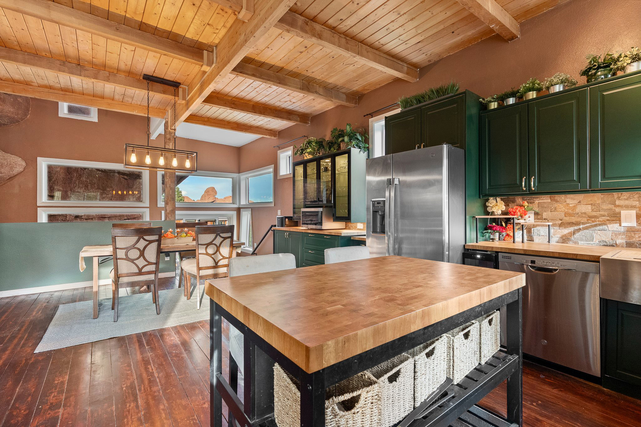 Kitchen and dining area inside The Rock House in Larkspur Colorado featuring butcher block countertops, custom cabinetry, and sandstone views