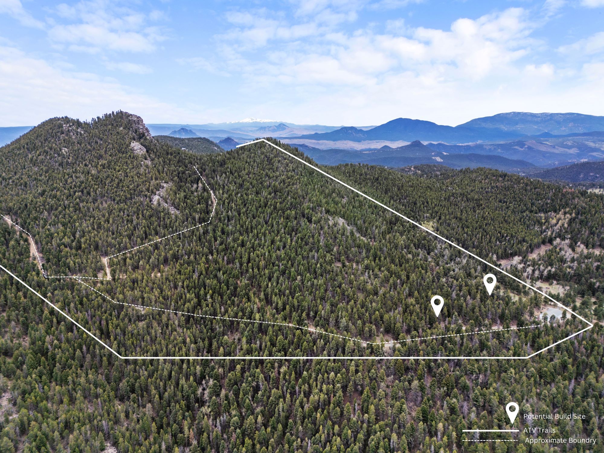 Expansive forested mountain land in Conifer, Colorado with outlined borders, designated trails, and buildable sites overlooking distant ranges.