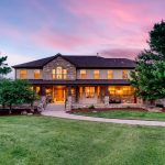 Sold home at 7530 Flintwood Rd, Parker, Colorado — two-story stone and stucco exterior with large covered front porch and landscaped lawn at sunset.