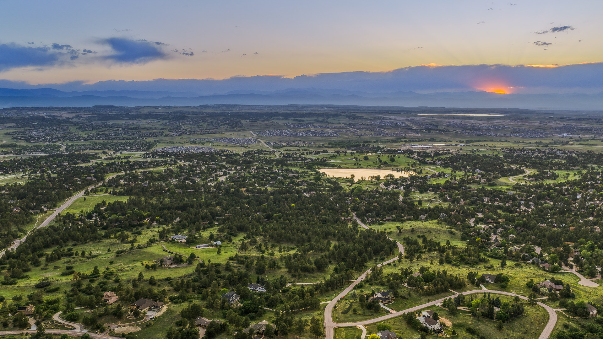 Aerial view at dusk of The Pinery neighborhood in Parker, Colorado, with the Front Range on the horizon